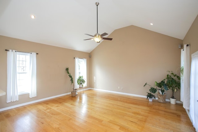 empty room with lofted ceiling, light wood-style floors, and a wealth of natural light