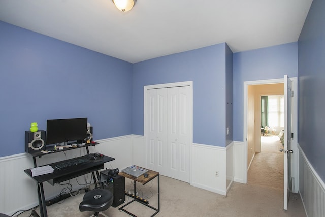 carpeted office space with a wainscoted wall