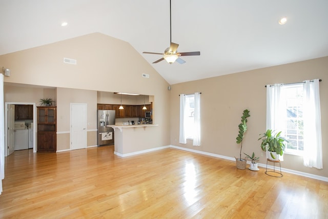 unfurnished living room with visible vents, baseboards, light wood-type flooring, a ceiling fan, and separate washer and dryer