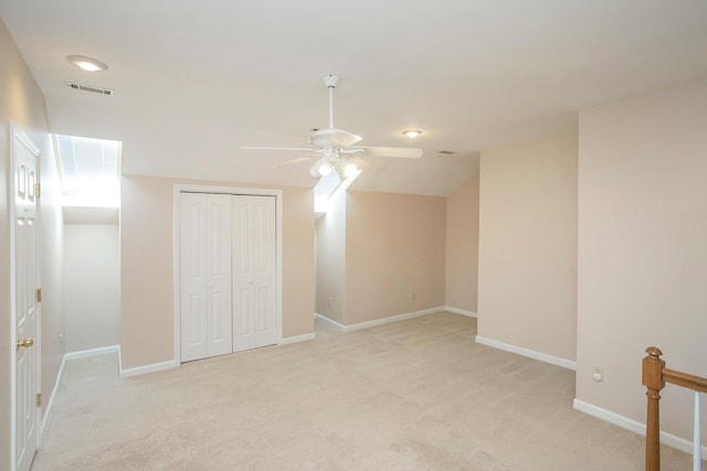 unfurnished bedroom with a closet, visible vents, light colored carpet, and baseboards