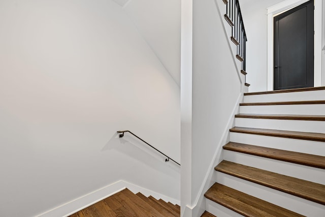 staircase with baseboards and wood finished floors