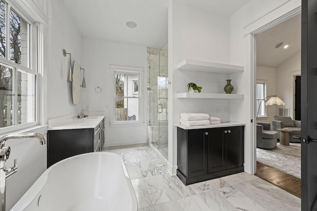 full bathroom with plenty of natural light, marble finish floor, a freestanding bath, and a shower stall