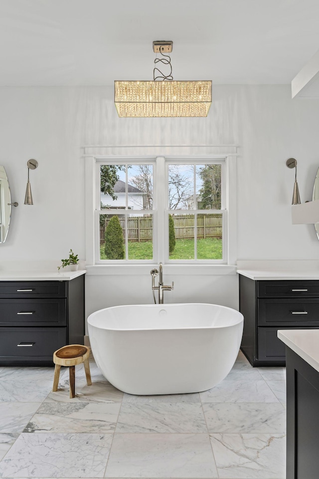 bathroom featuring a wealth of natural light, marble finish floor, and vanity