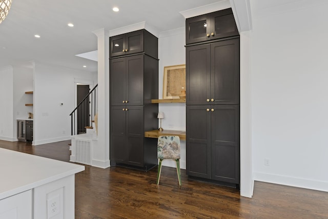 kitchen featuring baseboards, recessed lighting, dark wood-type flooring, glass insert cabinets, and crown molding