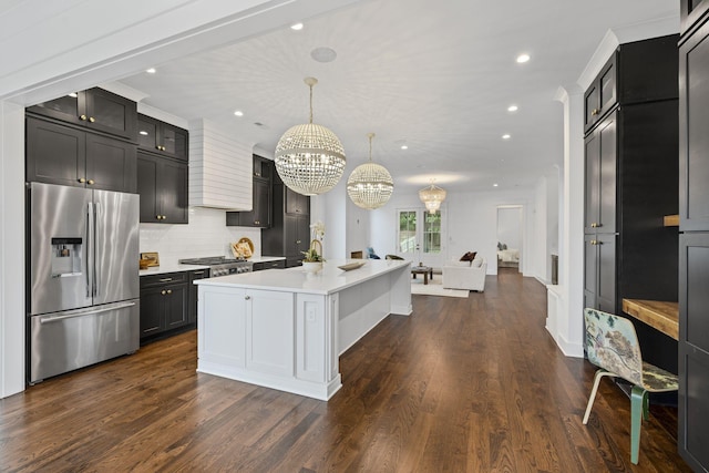 kitchen featuring dark wood-type flooring, stainless steel refrigerator with ice dispenser, light countertops, custom exhaust hood, and a chandelier