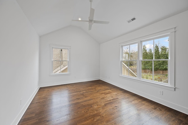 spare room with visible vents, a ceiling fan, baseboards, dark wood-style flooring, and vaulted ceiling