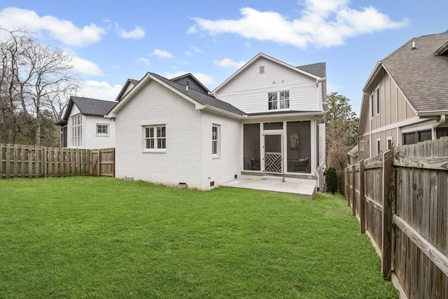 back of house with brick siding, crawl space, a lawn, and a sunroom