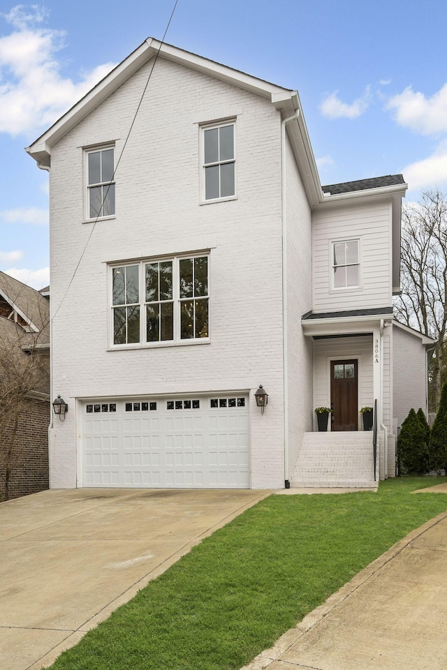 traditional home with a front lawn, an attached garage, and brick siding