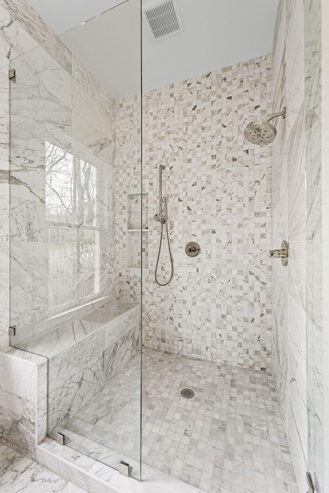 full bath with visible vents and tiled shower