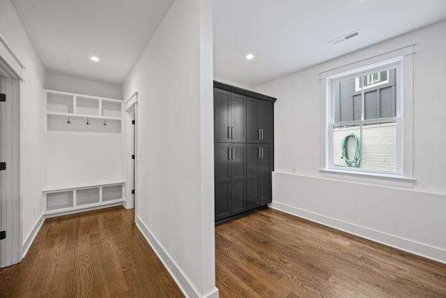 mudroom with visible vents, baseboards, and dark wood finished floors