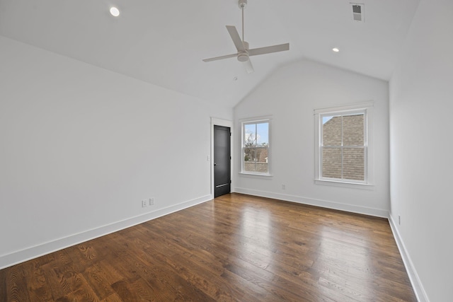 empty room featuring vaulted ceiling, dark wood-style floors, baseboards, and ceiling fan