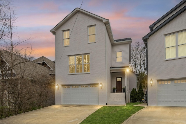 traditional home featuring brick siding, driveway, and an attached garage