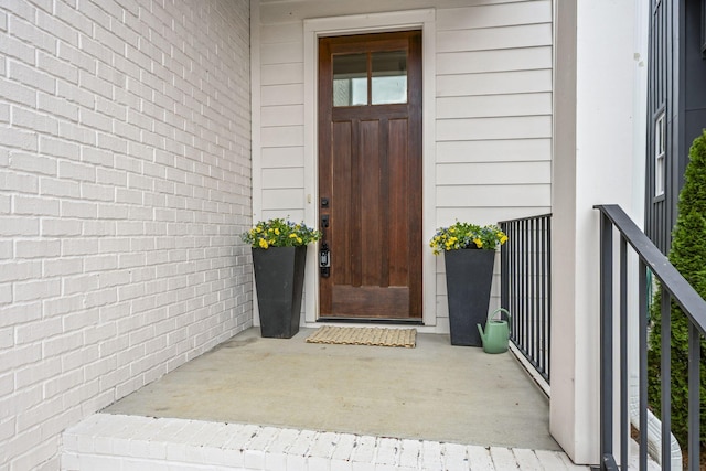 view of exterior entry with brick siding