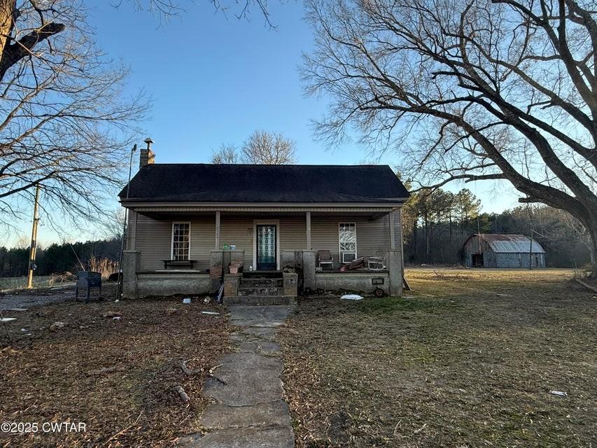 view of front facade featuring a porch and a chimney