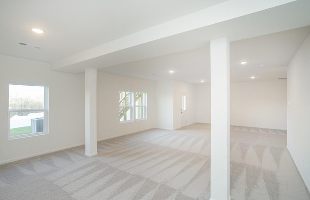 below grade area with light carpet, visible vents, and recessed lighting