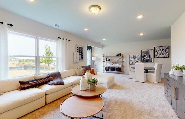 living room featuring visible vents, recessed lighting, and light colored carpet