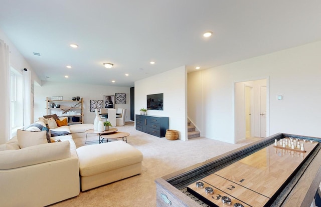 living room with stairs, recessed lighting, and light colored carpet