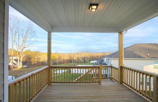 wooden terrace featuring a lawn