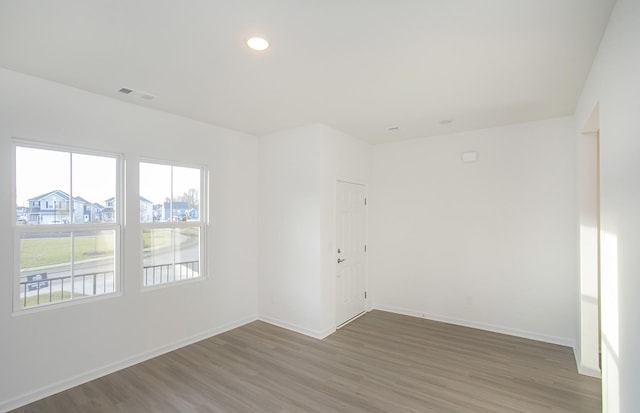 empty room featuring visible vents, recessed lighting, wood finished floors, and baseboards