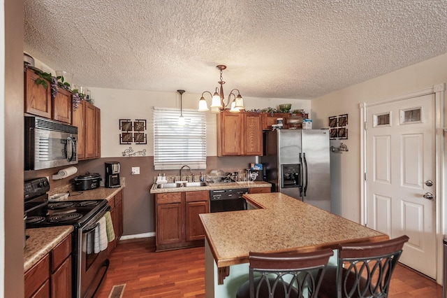 kitchen with brown cabinets, stainless steel appliances, light countertops, and a sink