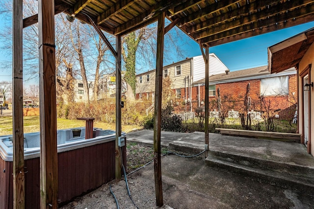 view of patio / terrace featuring a residential view and a hot tub