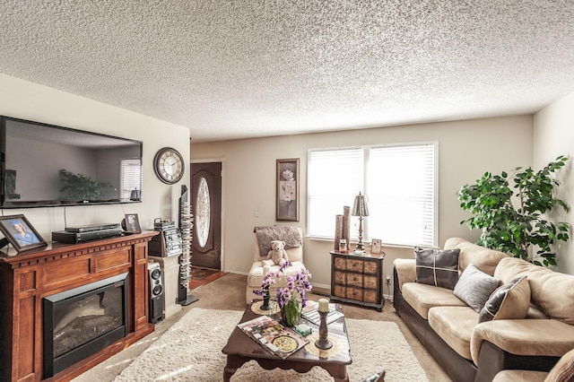 living area with a glass covered fireplace, light colored carpet, and a textured ceiling