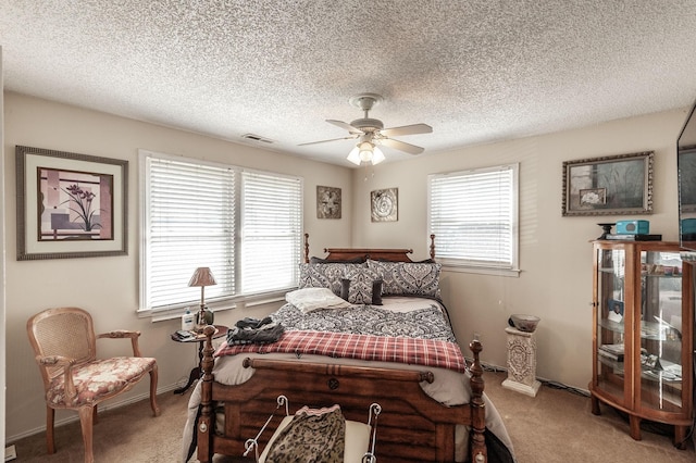 bedroom featuring multiple windows, visible vents, carpet floors, and ceiling fan