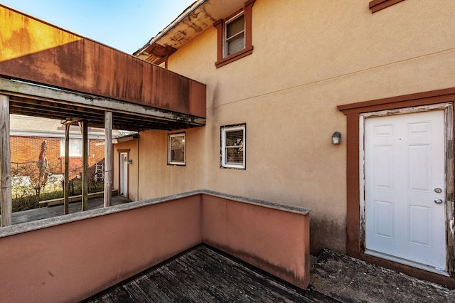 exterior space with stucco siding and a balcony