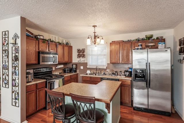 kitchen with light countertops, dark wood-style floors, brown cabinets, and stainless steel appliances