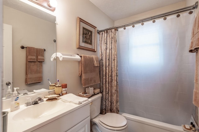 bathroom with shower / bath combo with shower curtain, a textured ceiling, toilet, and vanity