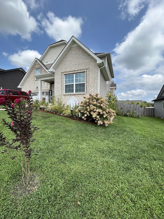 view of front of property featuring brick siding, a front lawn, and fence