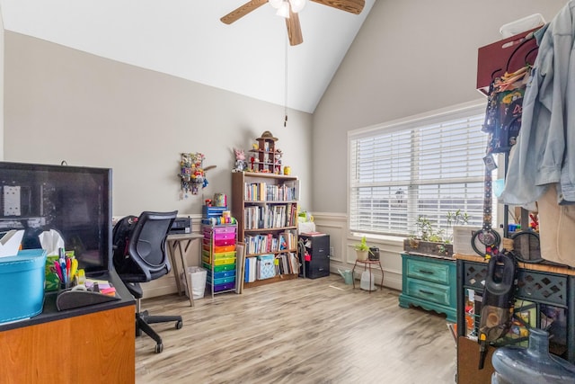 home office with ceiling fan, wood finished floors, wainscoting, and vaulted ceiling