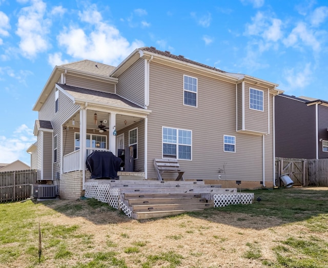 rear view of property with a ceiling fan, fence, a yard, a wooden deck, and central AC unit