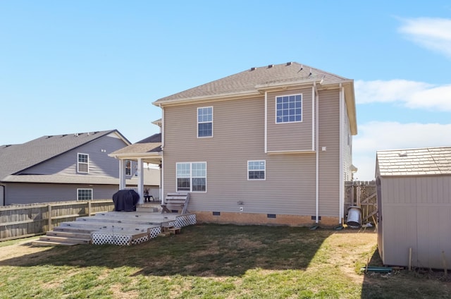 back of house with crawl space, a fenced backyard, an outdoor structure, and a yard