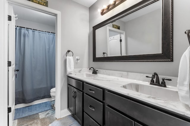 full bath with double vanity, toilet, a shower with shower curtain, and a sink