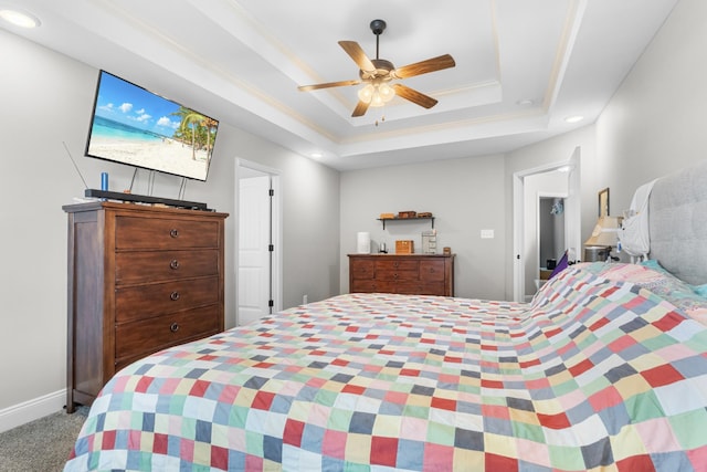 carpeted bedroom featuring baseboards, a raised ceiling, ceiling fan, and ornamental molding