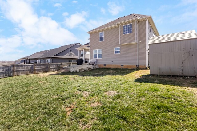 rear view of property with crawl space, a lawn, and fence