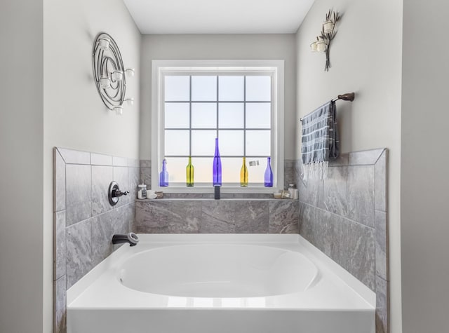 bathroom featuring plenty of natural light and a bath