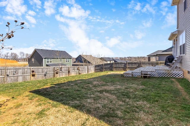 view of yard with a deck, a fenced backyard, and a residential view