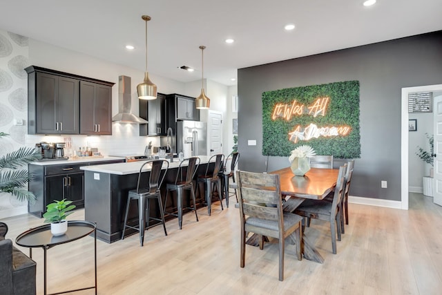 dining room featuring recessed lighting, baseboards, and light wood finished floors