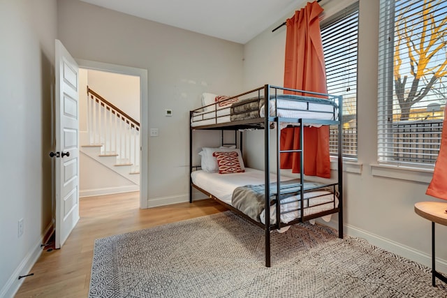 bedroom with wood finished floors and baseboards