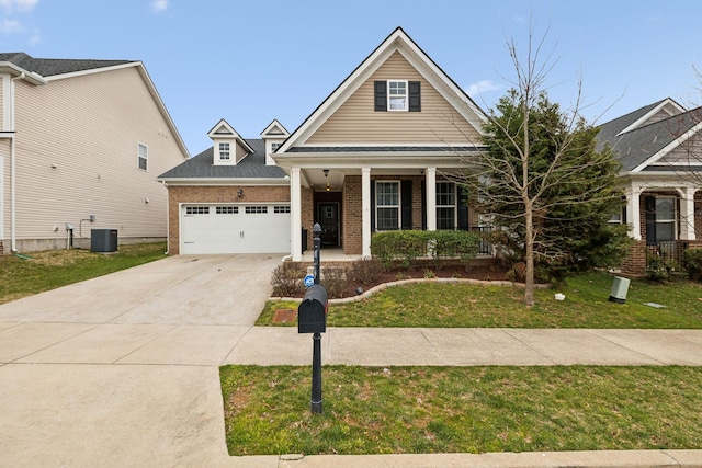 traditional home with a front lawn, driveway, a garage, brick siding, and central AC unit