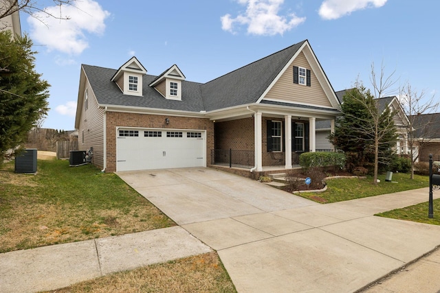 view of front of property with brick siding, a front lawn, a porch, concrete driveway, and central AC unit