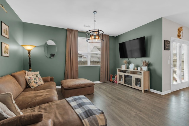 living area with visible vents, baseboards, and wood finished floors