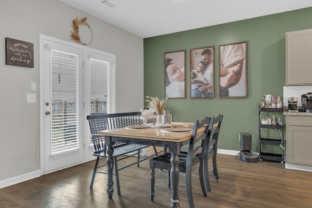 dining area with visible vents, baseboards, and dark wood-style floors