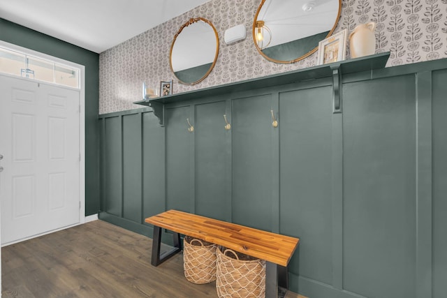 mudroom with dark wood finished floors, a decorative wall, wallpapered walls, and a wainscoted wall