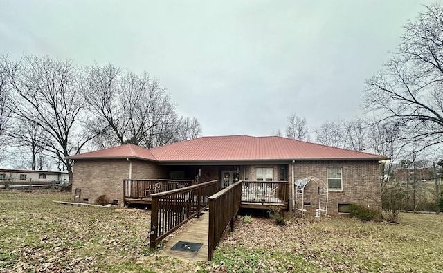 back of house with brick siding, crawl space, metal roof, and a wooden deck