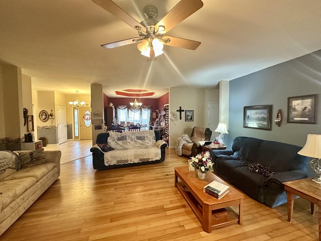 living room featuring ceiling fan with notable chandelier and light wood-type flooring