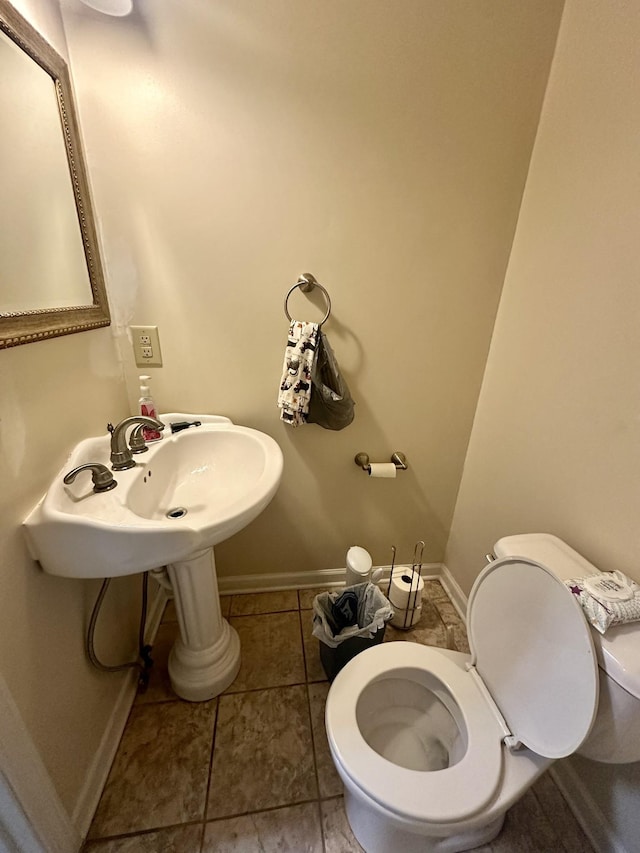 bathroom with tile patterned floors, toilet, and baseboards