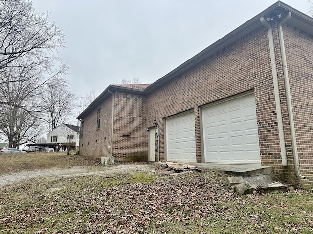 view of property exterior featuring brick siding and an attached garage